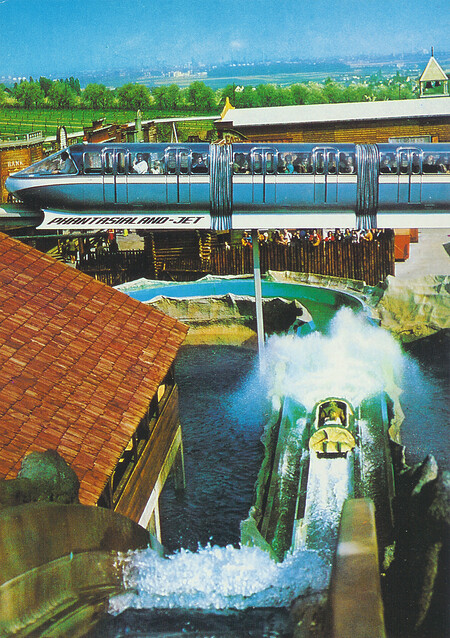 Phantasialand-Jet, Monorail-Einschienenzug mit Wildwasserbahn und Westernstadt im Hintergrund.